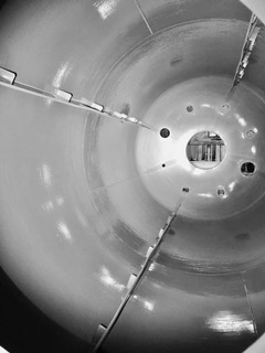 Coated interior of an industrial drum, showing the curved walls and openings