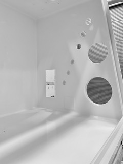 Coated interior surfaces and circular openings in a glovebox hood