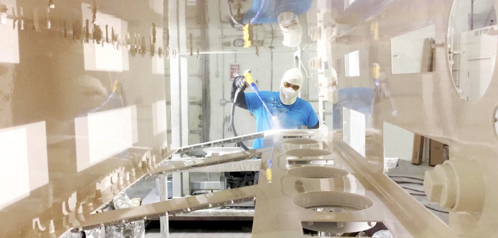 Fisher Company technician applying a coating to industrial equipment